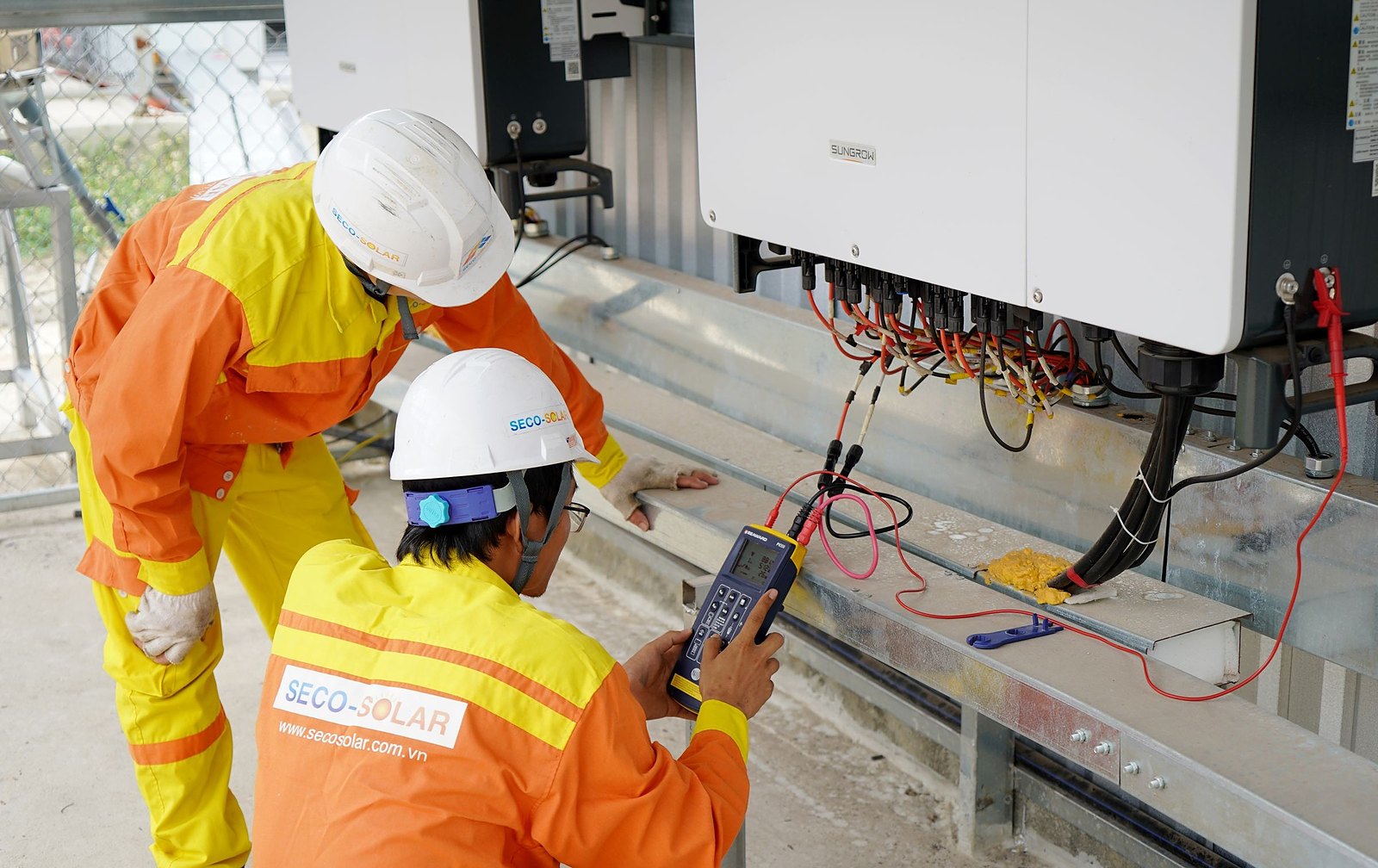 Engineers testing a commercial solar inverter
